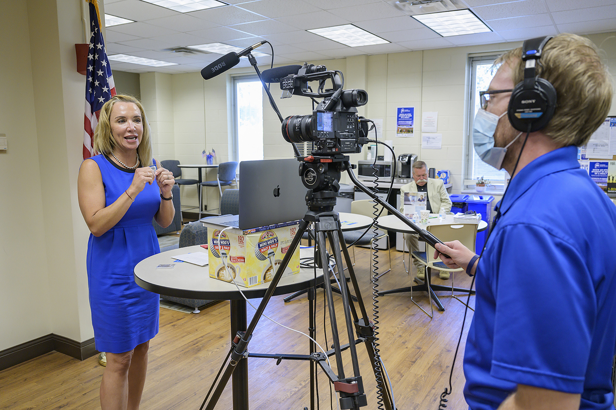 Hilary Miller, left, director of the Charlie and Hazel Daniels Veterans and Military Family Center, show graduating senior veterans the alumni coin they will receive Wednesday, Aug. 5, during the summer Graduating Veterans Stole Ceremony, as Marketing and Communications staff member Joe Poe films this segment in the KUC. (MTSU photo by Andy Heidt)