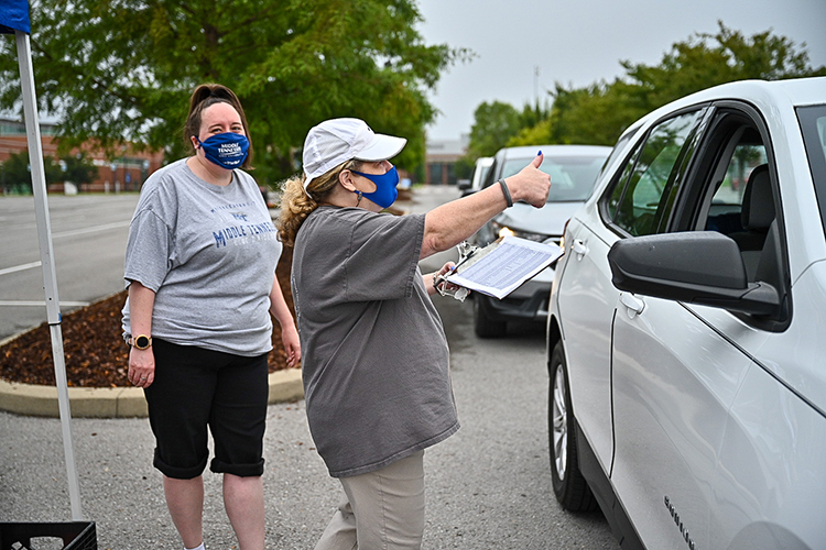 Michelle Safewright of MTSU's Parking and Transportation Services gives a big thumbs-up to a student picking up a parking permit for the new academic year as colleague April Branson, left, looks on with a smile in a special drive-through checkpoint Wednesday, Aug. 19. Students are moving in to MTSU dorms this week by individual appointment, instead of the customary two-day open event, to help maintain health safety conditions, and Parking Services joined the move-in checkpoint line to make the process more efficient. Fall semester classes begin Monday, Aug. 24. (MTSU photo by J. Intintoli)