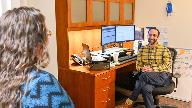 Andrea Smith, executive aide to the associate dean, and John Davis, graduate analyst, chat while socially distancing at the MTSU College of Graduate Studies on Oct. 15, 2020. (MTSU photo by Stephanie Barrette)