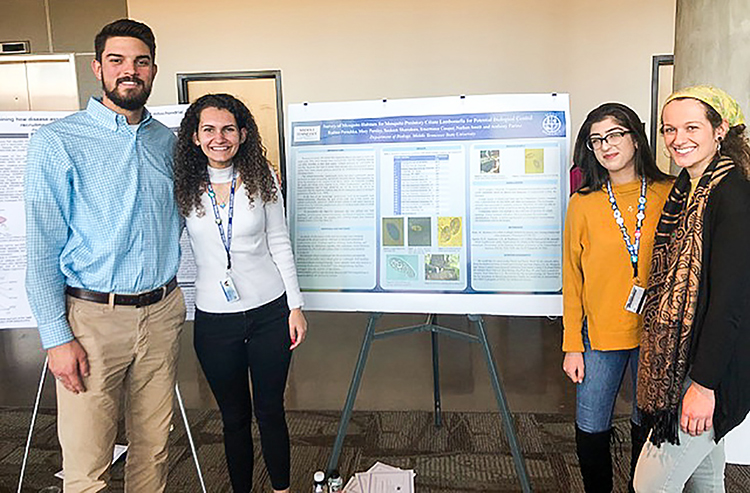 Members of MTSU’s undergraduate research group SOAR, which stands for Student Organization for the Advancement of Research, smile with a project at the 2019 Undergraduate Research Center Fall Open House on Nov. 15, 2019 at MTSU. Standing, from left, are Nathan Smith, Radina Porashka, Sauleen Shamdeen and Mary Parsley. (MTSU photo by Jamie Burriss)