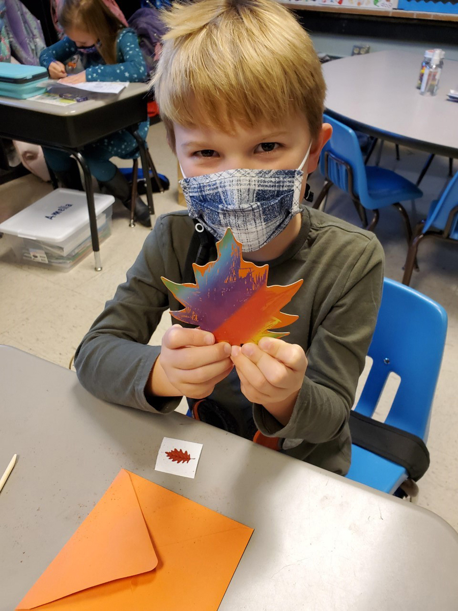 Brooks Bergsieker, a student in teacher Anne Mayes’ class at Homer Pittard Campus School, holds a colorful leaf that was part of the items in the 80 harvest handbags made and delivered by MTSU School of Agriculture agritourism students. (Submitted photo by Campus School)