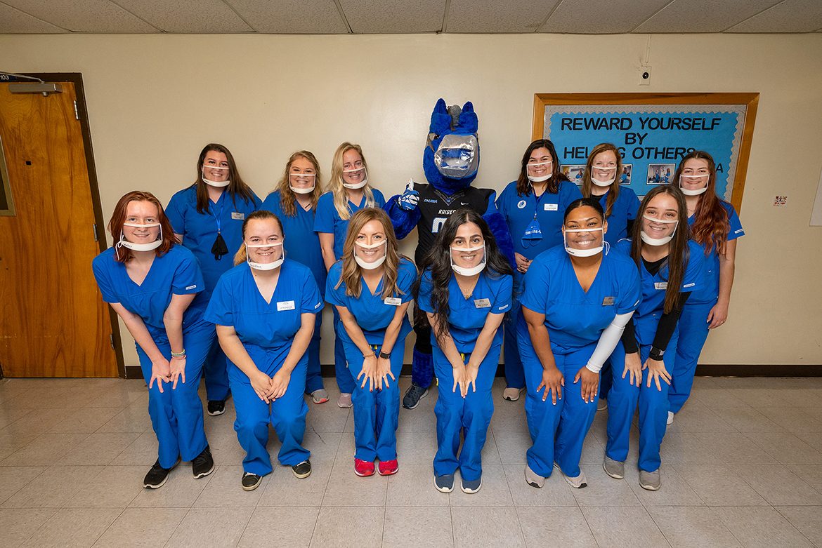 Student clinicians at MTSU's Speech-Language-Hearing Clinic pose for a group photo wearing their clear masks that enable clients to see how their lips move. Front row, l to r, Maggie Waller, Lexie Daddone, Amber Hayden, Rena Bamerini, Alana Crenshaw, and Delaney Freeze. Back row, l to r, Emily Hines, Lindsey Lamb, Avery Kaumayer, MTSU mascot Lightning, Kaylee Skipper, Madison Hoback, and Lana Chaney. (MTSU Photo by Andy Heidt)