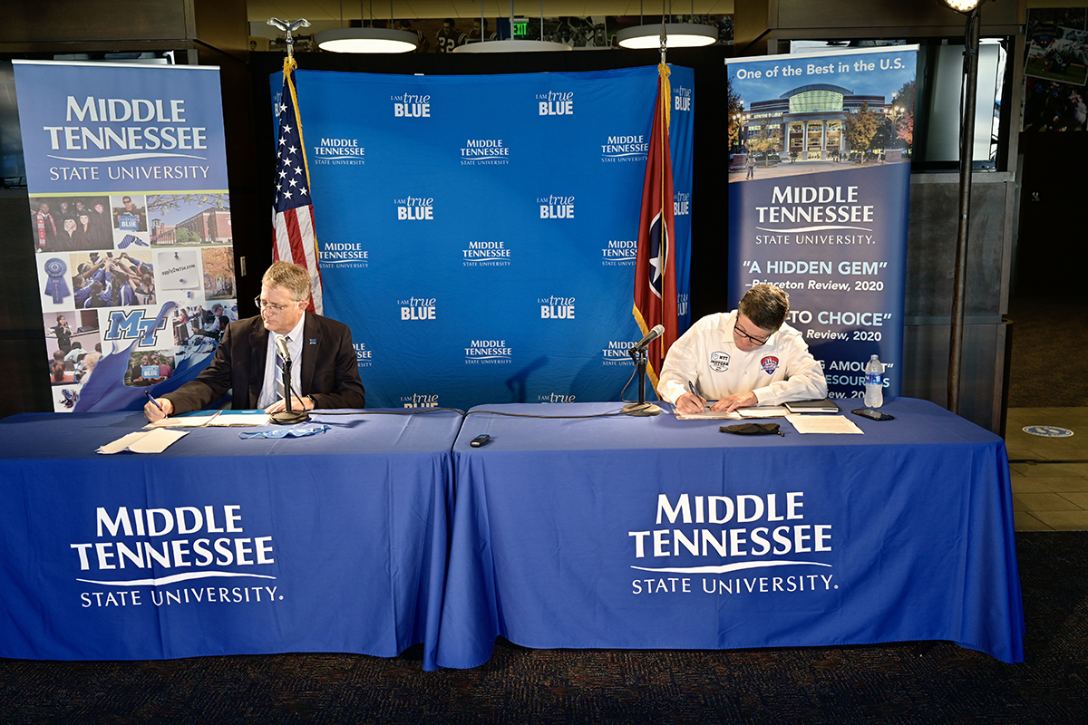 MTSU Provost Mark Byrnes, left, and Music City Grand Prix CEO and university alumnus Matt Crews sign the agreement, celebrating the partnership allowing the university’s acclaimed concrete program and its students to create special environmentally conscious mixes for barriers and pit row for the August 2021 open-wheel race in downtown Nashville, Tennessee. Crews is a former Jones College of Business student and Blue Raider football player. (MTSU photo by Andy Heidt)