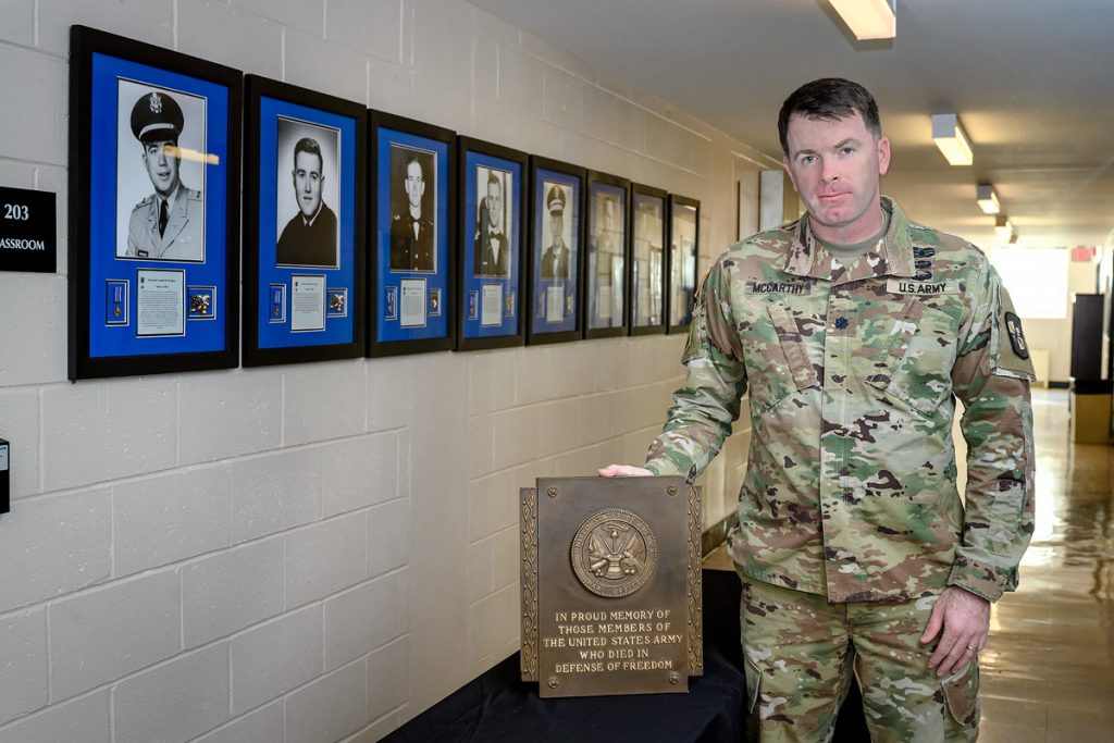 U.S. Army Lt. Col. Carrick McCarthy, who heads the MTSU Military Science program, is shown with a group of eight shadowbox photo displays of former university ROTC cadets who died in combat while serving their country, and an accompanying plaque in Forrest Hall. The shadowboxes will be on display at the Veterans Memorial outside the Tom H. Jackson Building, 628 Alma Mater Drive, leading to the 39th annual Salute to Veterans and Armed Services game between MTSU and FIU in Floyd Stadium. This marks the 71st anniversary of the program. (MTSU file photo by J. Intintoli)