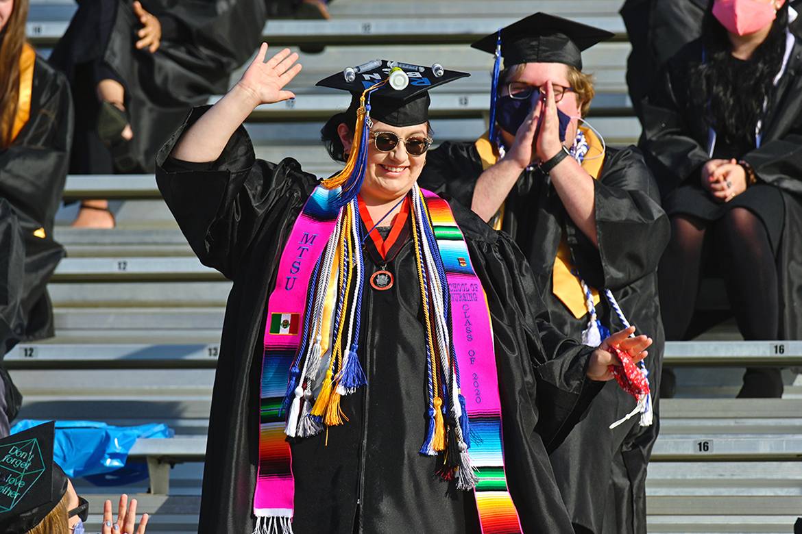 A new graduate of the MTSU School of Nursing waves as she's recognized on the Jumbotron at Floyd Stadium Saturday, Nov. 21, during the university's fall 2020 commencement ceremonies. MTSU, which held virtual graduations for its May and August graduates because of the pandemic, required strict mask, physical distancing and other health protocols for the graduates and limited their guests to help keep the three open-air events safer. (MTSU photo by Cat Curtis Murphy)