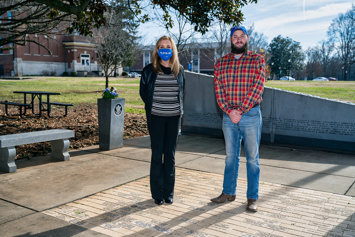 Hilary Miller, left, director of MTSU’s Charlie and Hazel Daniels Veterans and Military Family Center, and student veteran Orrin Farmer stand at the Veterans Memorial site outside the Tom H. Jackson Building recently. Farmer is one of dozens of military-connectred students assisted by two grants in 2020, helping them out during the COVID-19 pandemic. He is an aerospace professional pilot major from Casper, Wyoming. (MTSU photo by Andy Heidt)