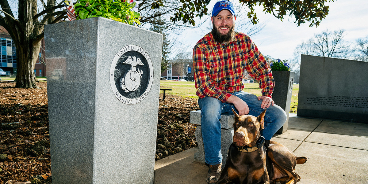 Along with his dog Loki, MTSU student veteran Orrin Farmer visits the MTSU Veterans Memorial site outside the Tom H. Jackson Building on the west side of campus recently. An aerospace professional pilot major, Farmer, who was in the U.S. Marine Corps for four years, was one of dozens of military-connected students who received assistance from a United Way of Rutherford and Cannon Counties $10,000 grant in 2020, providing help to he and his wife during the stressful COVID-19 pandemic. (MTSU photo by Andy Heidt)