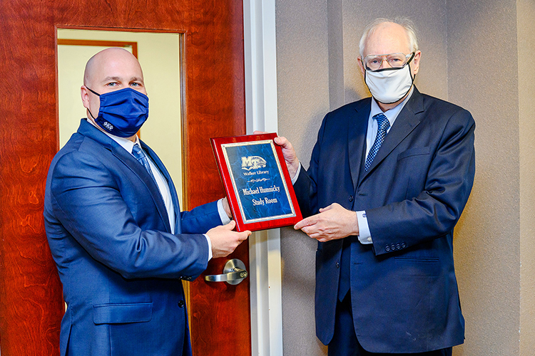 Michael Humnicky, right, and Jason Martin, interim dean of the James E. Walker Library, display the plaque naming a study room after Humnicky to honor his donations. (MTSU Photo by J. Intintoli)