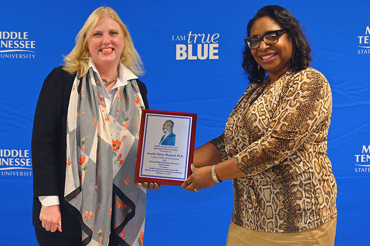 Jennifer Woodard, right, associate dean of the MTSU College of Media and Entertainment, holds her 2021 John Pleas Faculty Award as her dean, Beverly Keel, looks on at a Feb. 24 livestreamed ceremony from Keathley University Center Theater. (MTSU photo by Cat Curtis Murphy)