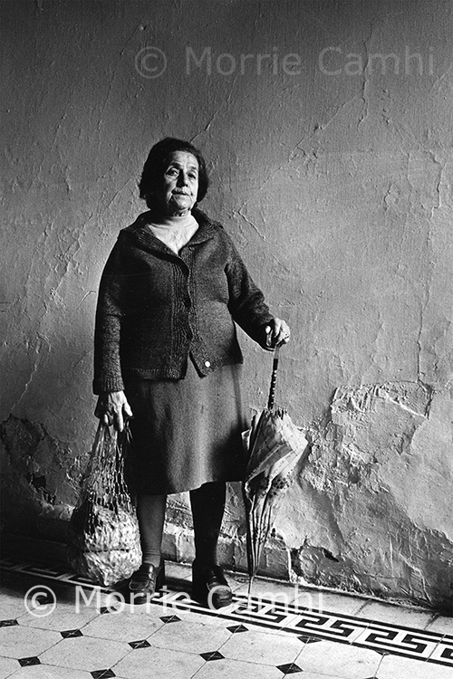 Documentary photographer Morrie Camhi's image of "Serina Matsas, at home, Ioannina, 1980" depicts a woman standing in a hallway with her woven shopping bag and an umbrella in Ioannina, Greece, part of Camhi's "Faces and Facets: The Jews of Greece" collection. This photo is among those in a new exhibit in MTSU's Baldwin Photographic Gallery, "An Eye Towards Justice," on display through Thursday, April 15. The exhibit and Camhi's work also are the subject of an online panel discussion with MTSU faculty experts set for Tuesday, March 30, at 6:30 p.m. Central. (photo by Morrie Camhi)