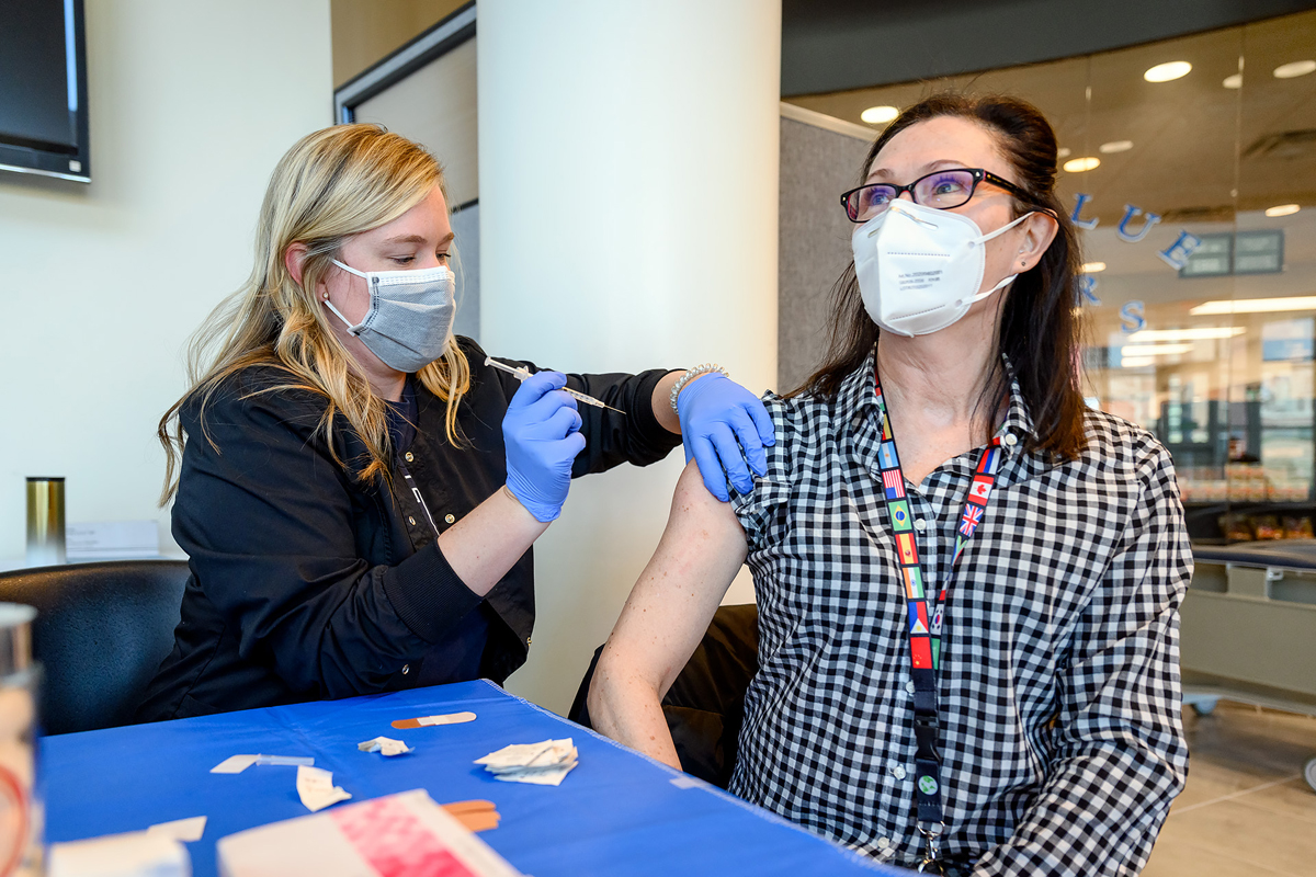 MTSU Health Services nurse practitioner Kendra Todd, left, administers the Moderna vaccine to Andrea Sakoff, a secretary in Murphy Center, on Wednesday, March 3, in the Health, Wellness and Recreation Center. Health Services opened a COVID-19 vaccination clinic to serve MTSU faculty, staff, students and retirees who meet current state eligibility protocols. The vaccine clinic will take place from 9 a.m. to 2:30 p.m. each weekday, by appointment only, in the Rec Center lobby. This clinic is operated independently from the community vaccination clinic hosted by the School of Nursing in the Cason-Kennedy Nursing Building. (MTSU photo by J. Intintoli)