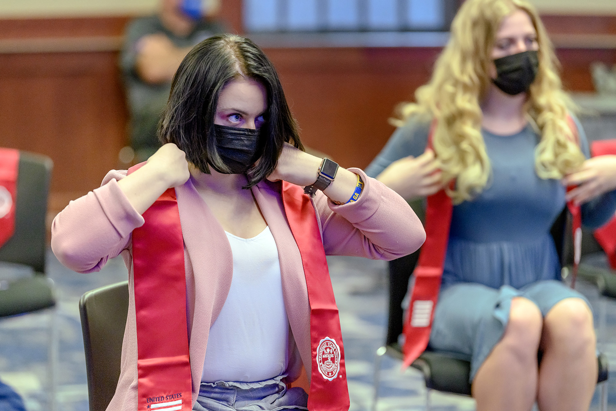 MTSU senior Jordan Plumb, left, of La Vergne, Tenn., adjusts her red stole during the Graduating Veterans Stole Ceremony Wednesday, April 28, in the Sam Ingram Building’s MT Center. In May, Plumb will be commissioned as a second lieutenant and will begin her U.S. Army career in Korea. (MTSU photo by J. Intintoli)
