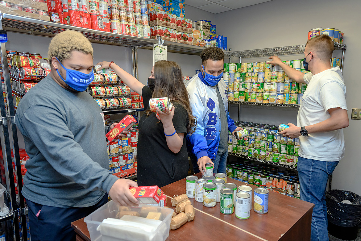 Volunteers help stock the shelves at the Student Food Pantry in the MT One Stop April 14. During Greek Week April 12-16, Fraternity and Sorority Life and the Student Government Association combined to collect more items than the pantry has received before. From left, Ryan Offutt, Greek Week Committee member; Jordan McCain, Greek Week Committee chair; Jalen Everett, National Pan-Hellenic Council president; and Alex Wissert, Interfraternity Council president. (MTSU photo by J. Intintoli)