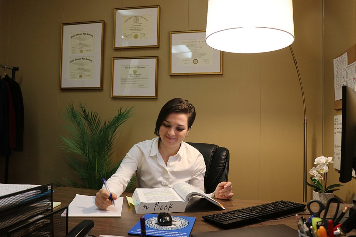 Kaitlin Beck, an MTSU alumna and assistant public defender in the Shelby County Public Defender’s Office in Memphis, researches a suppression issue related to a client’s stop and arrest. Items on her office wall include framed certificates from her two MTSU bachelor’s degrees (French Language and Economics), law degree, license to practice and “Order of Admission” into the Tennessee Bar, permitting her to practice law in Tennessee, from the Tennessee Supreme Court. MTSU alumnus Lee Whitwell made the motion for her admission. (Submitted photo by Margaret Mahaffey)