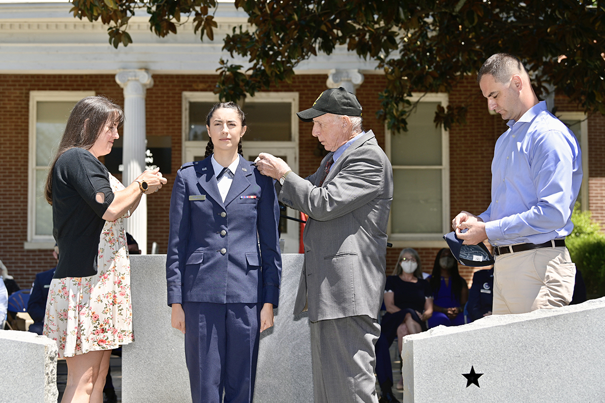 Recent MTSU aerospace aviation management graduate Kendra Pomeroy, center, has her U.S. Air Force second lieutenant bars placed on her uniform by her mother, Jean Aubin, left, of Charlotte, North Carolina, and grandfather, Larry Weidenhamer, of Tennessee, as her father, Craig Pomeroy, of Sterling, Mass., holds the bars for her flight cap during the Air Force ROTC Detachment 790/Tennessee State University spring commissioning ceremony May 15 at the Veterans Memorial outside the Tom H. Jackson Building. The event was sponsored by the Charlie and Hazel Daniels Veterans and Military Family Center. (MTSU photo by Andy Heidt)