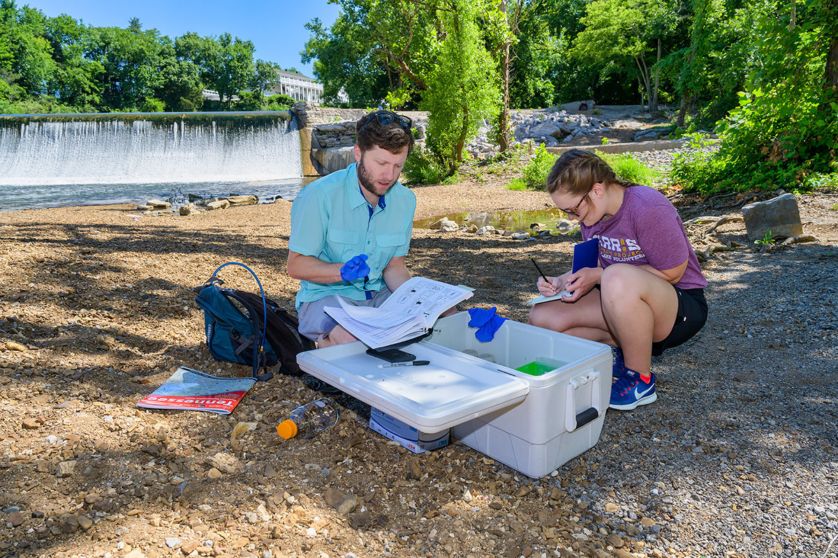 MTSU biology research assistant professor Cole Easson, left, and rising senior Jacqueline Williams of Drummonds, Tenn., check the reading a special pump that will provide data from their Stones River Watershed project that officially begins July and ends next spring when Williams writes her Honors College thesis and presents and one or more conferences. They will map aquatic diversity using next-generation sequencing techniques relative to land use in the surface waters in the river. (MTSU photo by Andy Heidt)