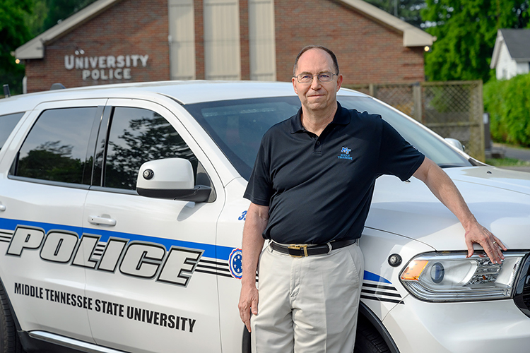Buddy Pester, police chief at Middle Tennessee State University, pictured here with a police cruiser at the department on May 28, 2021, recently retired after a 14-year tenure of protecting and serving the campus community. (MTSU photo by J. Intintoli)