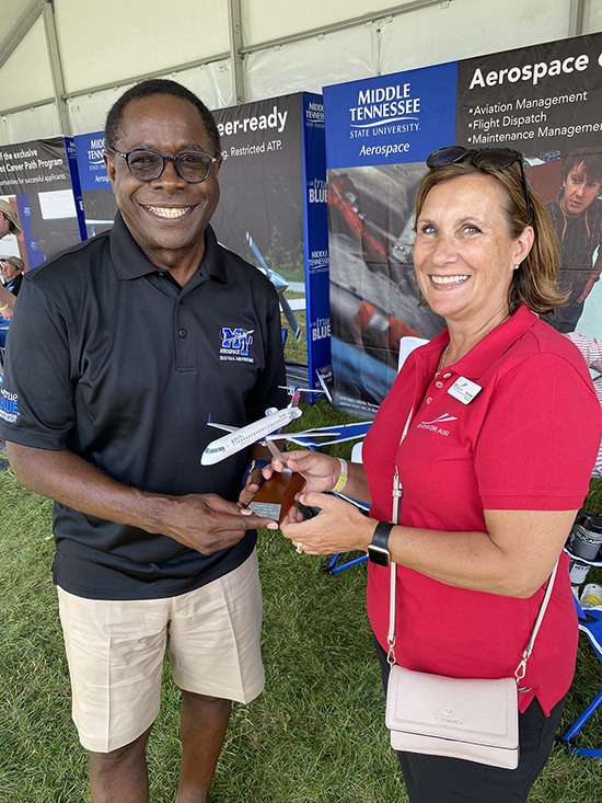 Ginny Zarras, right, human resources director for Endeavor Air, which flies as the Delta Connection, presents MTSU President Sidney A. McPhee with a token of appreciation for connecting the airline with outstanding MTSU graduates. Middle Tennessee State University’s Aerospace Department staffed a booth on the grounds of the air show held July 26-Aug. 1 in Oshkosh, Wisc. (MTSU photo by Andrew Oppmann)