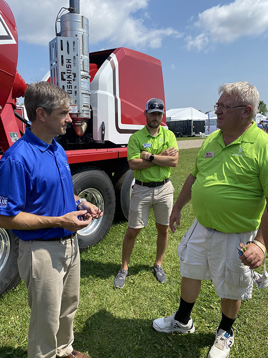 Greg Van Patten, left, interim dean of the MTSU College of Basic and Applied Sciences, meets with officials with the Oshkosh Corp. on behalf of MTSU’s School of Concrete and Construction Management on the grounds of the EAA AirVenture 2021, which runs July 26-Aug. 1 in Oshkosh, Wisc. The corporation, which makes concrete trucks and other heavy equipment, had a presence at EAA. (MTSU photo by Andrew Oppmann)