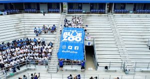 A group of MTSU students unfurl the giant Blue Zoo banner for the first time in two years on Thursday, Aug. 19, inside Floyd Stadium in preparation for the upcoming football season. (MTSU screen capture)