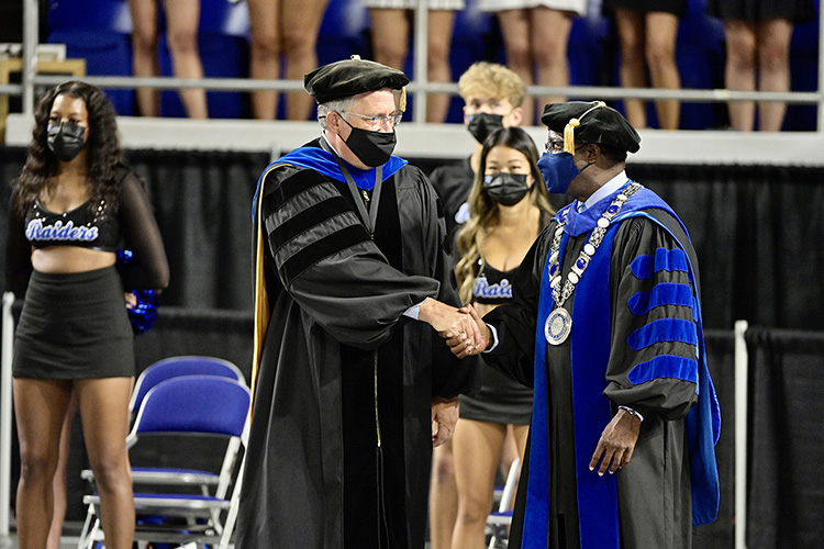 MTSU President Sidney A. McPhee, right, shakes hands with Provost Mark Byrnes as they march into Hale Arena for University Convocation held Saturday, Aug. 21, at Murphy Center. (MTSU photo by )