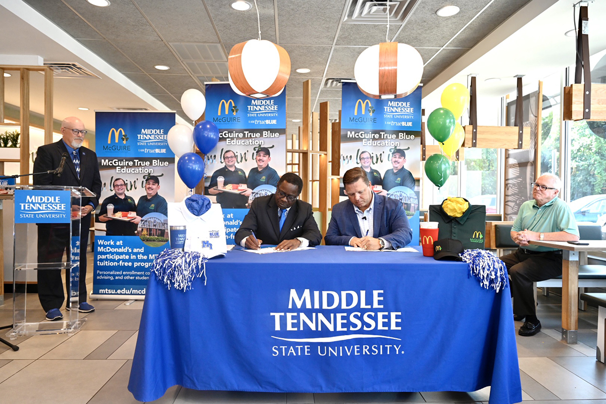 MTSU President Sidney A. McPhee, left, and McGuire Management Group owner/operator Jonathon McGuire sign the memorandum of understanding agreement formalizing the McGuire True Blue Education Partnership Wednesday, Aug. 4, at the McDonald’s franchise at 1706 Memorial Blvd., in Murfreesboro. The agreement calls for McGuire employees to attend MTSU tuition-free if they meet qualifying criteria. (MTSU photo by J. Intintoli)