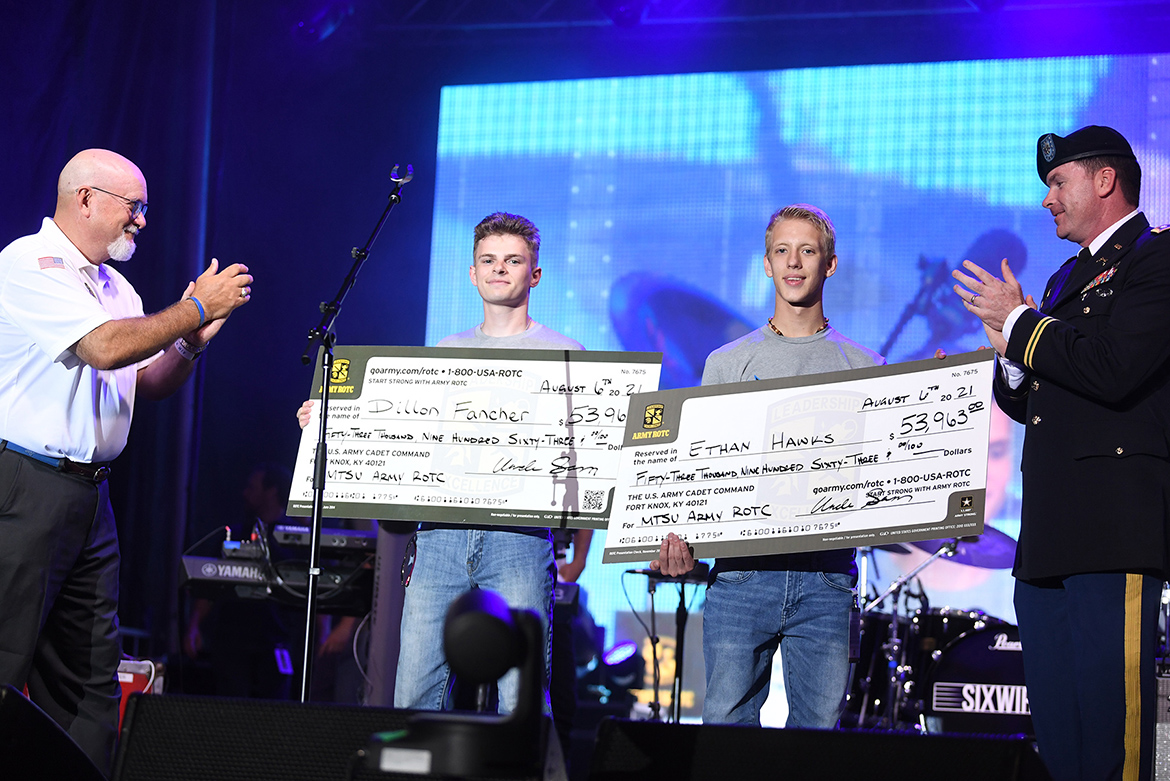 Two incoming MTSU freshmen and new ROTC cadets — Dillion Fancher and Ethan Hawks — are presented full Army Reserve Minuteman Scholarships during the Freedom Friday concert on Friday, Aug. 6, 2021, at the Big Machine Music City Grand Prix in Nashville, Tenn. The scholarships allow the students to attend MTSU and, upon graduation, be commissioned as second lieutenants in the Army Reserve. At far left is Army Reserve Ambassador Andrew Oppmann, an MTSU vice president who nominated the two cadets, and at far right is Army Lt. Col. Carrick McCarthy, MTSU’s professor of military science. (MTSU photo by James Cessna)
