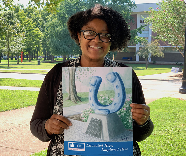 Dr. Leah Lyons, MTSU College of Liberal Arts interim dean and French professor, holds a copy of the “Educated Here, Employed Here” print by alumna and artist Catie Adams given by the MTSU Alumni Associationmto graduates who now work at the university. (MTSU photo by Randy Weiler)