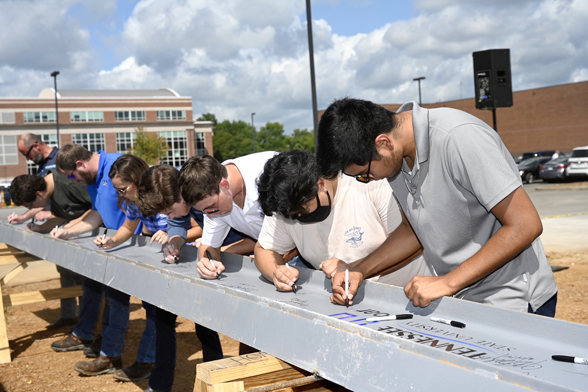 MTSU students sign the ceremonial final beam to be placed at the top of the School of Concrete and Construction Management building Tuesday, Sept. 14, near the Bragg Parking lot adjacent to the construction site. The 54,000-square-foot building is expected to be completed in 15 months, in time for Fall 2022 classes. The facility features classrooms, faculty and staff offices and laboratory space for Concrete Industry Management and Construction Management, both of which provide interns and ready-to-work graduates awaiting potentially lucrative careers. (MTSU photo by J. Intintoli)