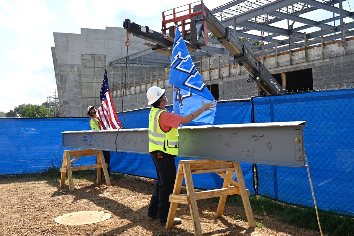 Project superintendents Wyatt Keeton, left, and Tom Hudson with Hoar Construction prepare the U.S. and MTSU flags placed on the final beam to be placed on top of the MTSU School of Concrete and Construction building Tuesday, Sept. 14. Campus officials celebrated with a topping-out ceremony near the construction site. (MTSU photo by J. Intintoli)