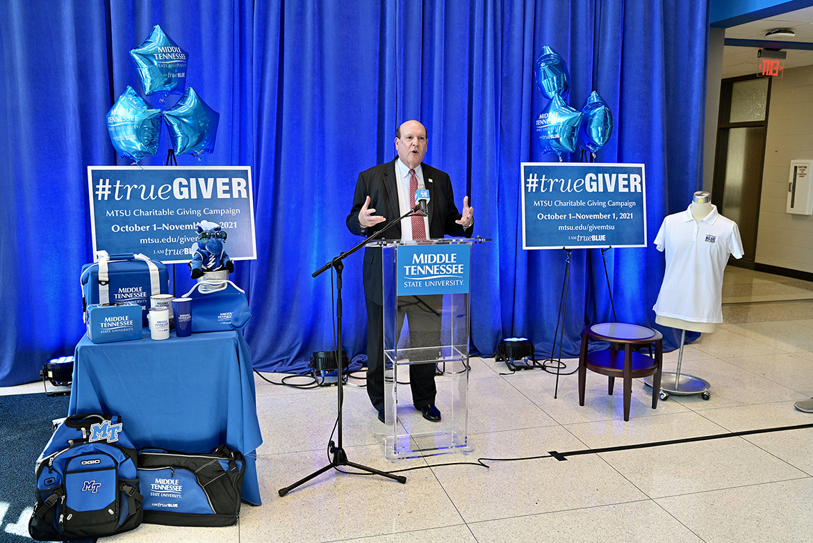 Dean David Urban of the Jennings A. Jones College of Business encourages colleagues to contribute during the kickoff of the 2021-22 MTSU Employee Charitable Giving Campaign held recently in the atrium of the Cope Administration Building. At left are giveaways of MTSU-branded and True Blue apparel and gear that will awarded during weekly drawings throughout the campaign. (MTSU photo by Andy Heidt)