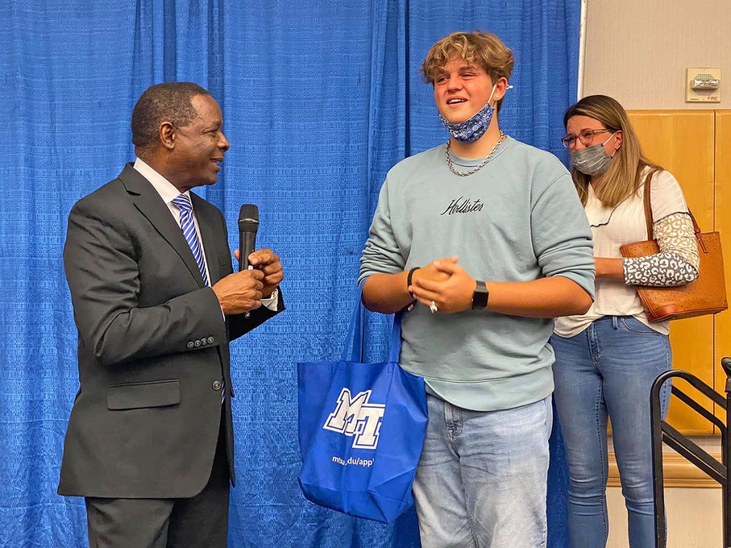 MTSU President Sidney A. McPhee, left, listens as Mason Taylor, a senior at Marion County High School in Jasper, Tenn., shares how much he has wanted to attend the Murfreesboro university after winning a $10,500 scholarship during the recent True Blue Tour recruiting event at the Chattanooga Convention Center. Dozens of students and their families attended the event, gathering material and getting their questions answered by MTSU staff. (MTSU photo by Andrew Oppmann)
