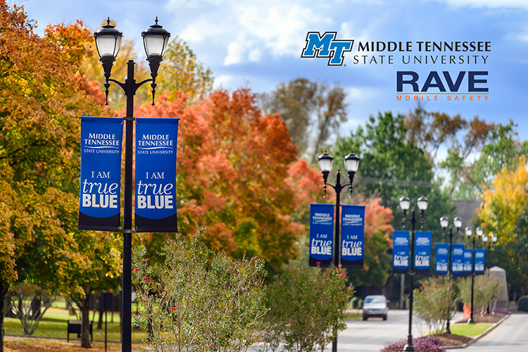 Fading autumn foliage and “I Am True Blue” banners line Old Main Circle at the East Main entrance to Middle Tennessee State University in this fall 2020 file image. The MTSU horizontal logo and the Rave Mobile Safety logo are at the upper right of the photo. (MTSU file photo by J. Intintoli)