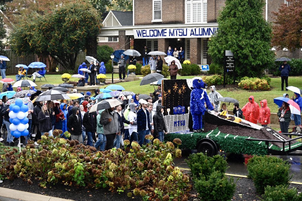 MTSU students walk with their float they created for the 2021 Homecoming Parade down Middle Tennessee Boulevard in front of The Alumni House. Rain did not dampen the spirits of those attending the annual event, held in-person after a one-year break because of COVID-19. (MTSU photo by J. Intintoli)