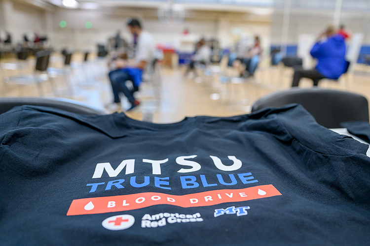 A new custom T-shirt is displayed in the foreground as donors fill out information sheets and wait to give blood in the background at MTSU's Student Health, Wellness and Recreation Center Monday, Nov. 1, on the first day of the university's annual three-day "True Blue Blood Drive." The American Red Cross-sponsored event collected 362 units of blood for the community, surpassing its 300-unit goal by 121%, and welcomed 152 first-time blood donors. (MTSU photo by J. Intintoli)
