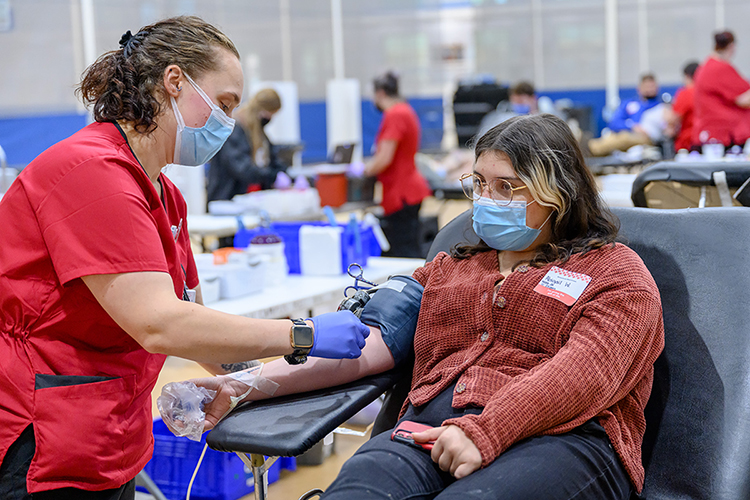 Nicole Kogowski, left, a phlebotomy supervisor with the American Red Cross, carefully prepares MTSU junior animation major Abigail Waddle of Munfordville, Ky., for her blood donation at the Student Health, Wellness and Recreation Center Monday, Nov. 1, on the first day of the university's annual three-day "True Blue Blood Drive." The American Red Cross-sponsored event collected 362 units of blood for the community, surpassing its 300-unit goal by 121%, and welcomed 152 first-time blood donors. (MTSU photo by J. Intintoli)