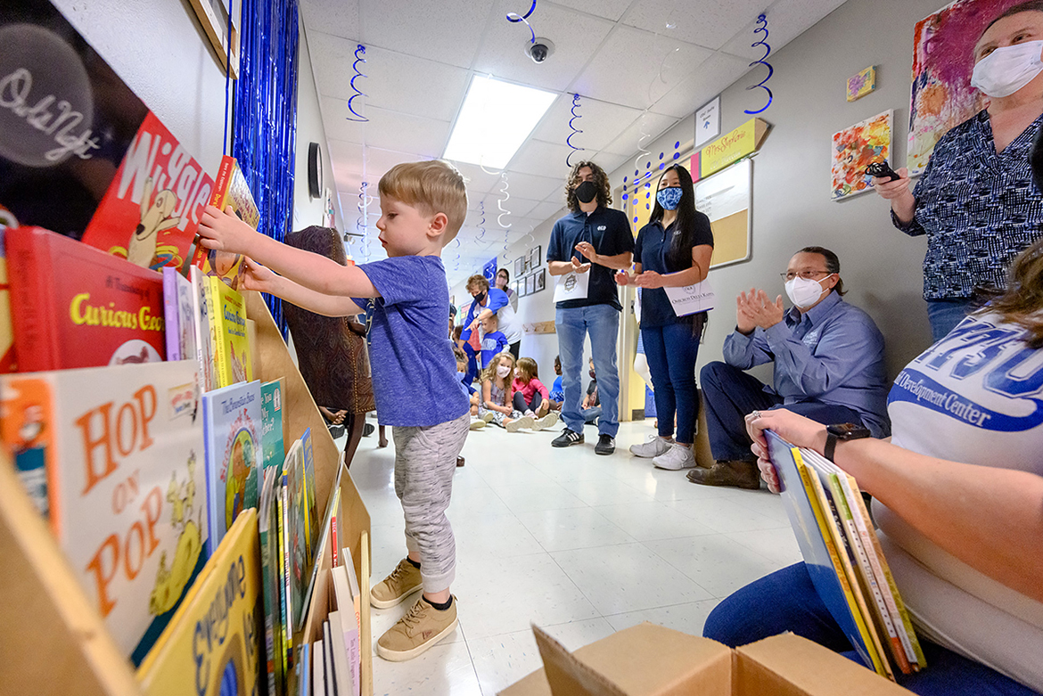Proudly wearing his MT shirt, Eddie Bennett places a book into the shelves of the Little Free Library at MTSU’s Child Development Center. At right, Phi Kappa Phi Student Vice Presidents Jared Frazier, Maria Hite and Nathan Wahl observe. (MTSU photo by J. Intintoli)
