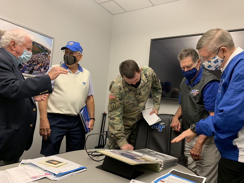 A group of MTSU Salute to Veterans and Armed Forces game committee members reminisce and view photos from scrapbooks they’ve kept through the years. Members include John Furgess, left, Don Witherspoon, U.S. Army Lt. Col. Carrick McCarthy, alumnus Bud Morris and retired U.S. Army Col. Rickey Smith. The committee has been preparing for the 39th Salute to Veterans game at 2:30 p.m. Saturday, Nov. 13, in Floyd Stadium, with many activities planned throughout the day. (MTSU photo by Randy Weiler)