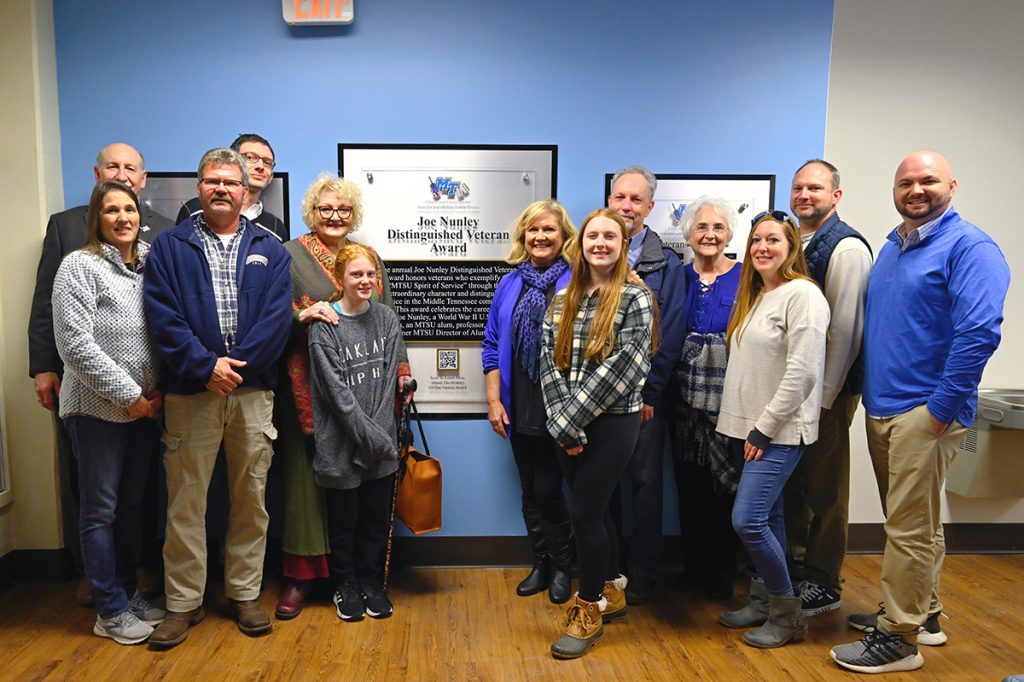 The family of the late Joe Nunley Sr. is shown at the new Joe Nunley Distinguished Veteran Award wall outside the MTSU Charlie and Hazel Daniels Veterans and Military Family Center on the first floor of the Keathley University Center. A ribbon-cutting ceremony Friday, Nov. 12, unveiled the area, honoring past and future Nunley award recipients recognized the the annual Salute to Armed Services football game in November. (MTSU photo by Cat Curtis Murphy)