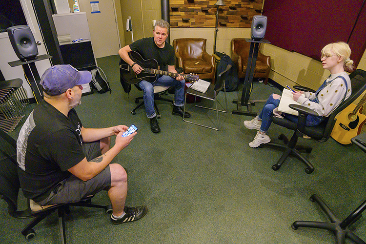 Veteran Jeremy Barker, left, an MTSU aerospace major from Murfreesboro, makes a suggestion while working with four-time SESAC Songwriter of the Year Regie Hamm and MTSU student songwriter Sarah Sexton, a senior from Smyrna, Tenn., on their song, “Late to the Party,” during the 2021 Operation Song retreat Oct. 29 at the university. The event teams trios of military veterans, student and professional songwriters to create healing music for the veterans and training for the students. (MTSU photo by Andy Heidt)