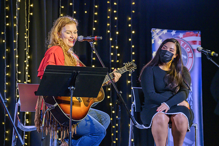 Singer-songwriter Kelli Johnson, left, grins while performing “This Is Why I’m Here,” a new song she wrote with veteran Danette Murphy of Clarksville, Tenn., an MTSU professional pilot major, right, and senior commercial songwriting major Adara Finnerty of Lone Grove, Okla., who's not pictured, during the 2021 Operation Song retreat Oct. 29 at the university. The event teams trios of military veterans, student and professional songwriters to create healing music for the veterans and training for the students. (MTSU photo by Andy Heidt)