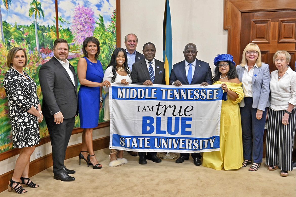 Bahamas Prime Minister Philip Davis, center right holding banner, joins MTSU President Sidney A. McPhee, center left of Davis, and his delegation to the Bahamas Bowl for a ceremonial photo Wednesday, Dec. 15. (MTSU photo by Andrew Oppmann)