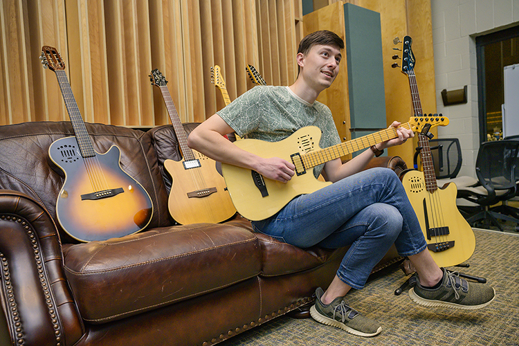 Cole Arn of Plant City, Fla., a graduate student and grad assistant in the Department of Recording Industry's Audio Engineering Program at Middle Tennessee State University, tries out a new Godin Guitars model A12 12-string electric in MTSU's Studio B in the Bragg Media and Entertainment Building on Dec. 16. The Montreal-based company donated eight electric guitars to the program for students like Arn, who's working toward his Master of Fine Arts in Recording Arts and Technologies degree, to use for recording projects. Like many of the Godin products, the all-North American wood guitar features an onboard preamp to let players customize their sound. (MTSU photo by Andy Heidt)