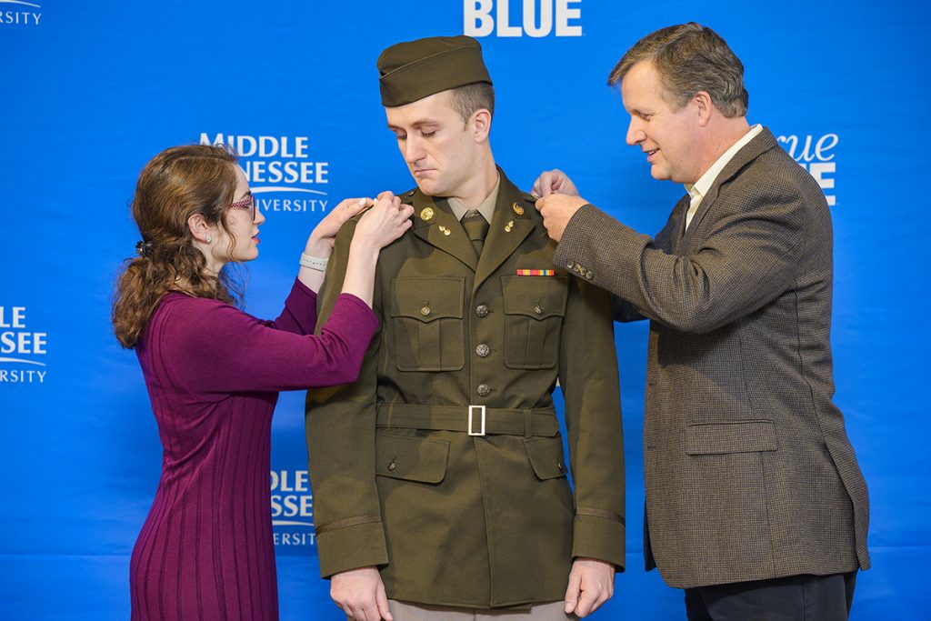 New U.S. Army 2nd Lt. Thomas Wiseman, center, of Murfreesboro, is pinned by his girlfriend, Annabelle Taylor, left, and his father John Wiseman, during the MTSU Blue Raider Battalion Fall 2021 Commissioning Ceremony in Tom Jackson Building’s Cantrell Hall Friday, Dec. 9. Thomas Wiseman earned his bachelor’s degree in nursing and will graduate Saturday, Dec. 11. (MTSU photo by Andy Heidt)