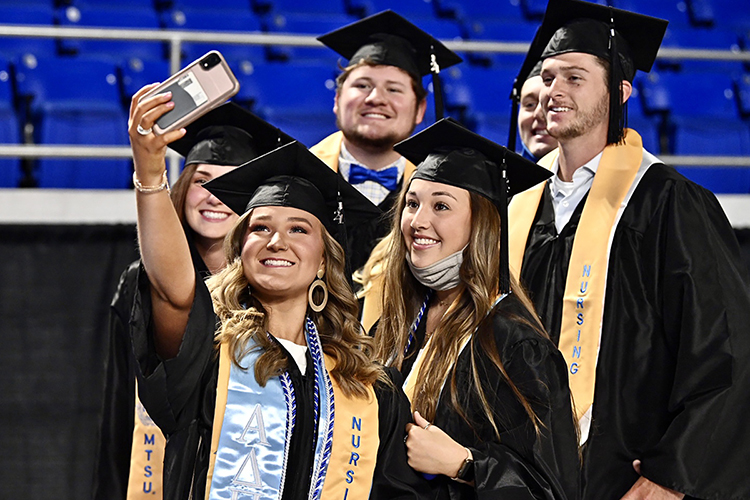 A group of graduating MTSU students pose for a group photo together before their spring 2021 commencement ceremony begins inside Murphy Center last May. Along with their special customized School of Nursing and Greek organization stoles, several wear braided cords indicating their status as Experiential Learning Scholars or with Undergraduate Research Graduation Distinction. (MTSU file photo by J. Intintoli)