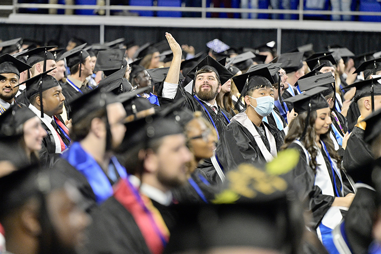 A graduating senior at MTSU acknowledges a friend while he and his fellow grads wait for the fall 2021 commencement ceremonies to begin in Murphy Center Saturday, Dec. 11. The university presented degrees to more than 1,670 students in three commencement events to conclude the fall semester. (MTSU photo by Andy Heidt)