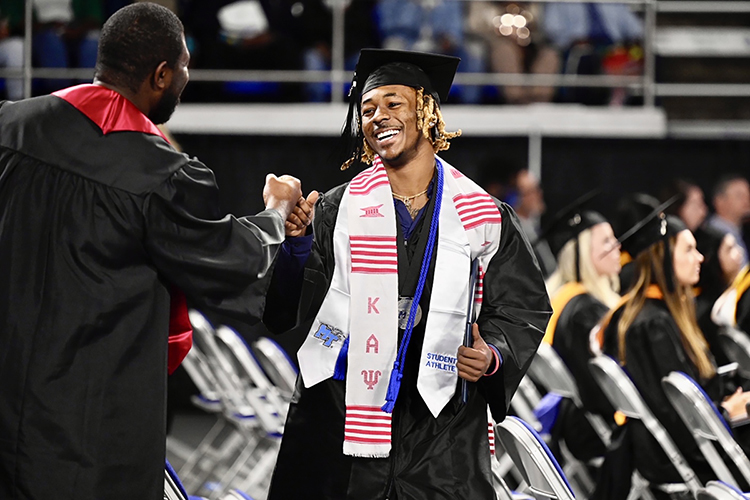MTSU graduating senior Brad Anderson II of Huntsville, Ala., greets a friend after accepting his bachelor's degree in exercise science at MTSU's fall 2021 commencement ceremonies Saturday, Dec. 11, inside Murphy Center. The university presented degrees to more than 1,670 students in three commencement events to conclude the fall semester. (MTSU photo by J. Intintoli)