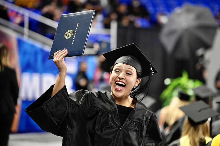 A graduating senior at MTSU's fall 2021 commencement ceremonies shouts with joy while she shows her new degree to supporters in the stands in Murphy Center Saturday, Dec. 11. The university presented degrees to more than 1,670 students in three commencement events to conclude the fall semester. (MTSU photo by J. Intintoli)