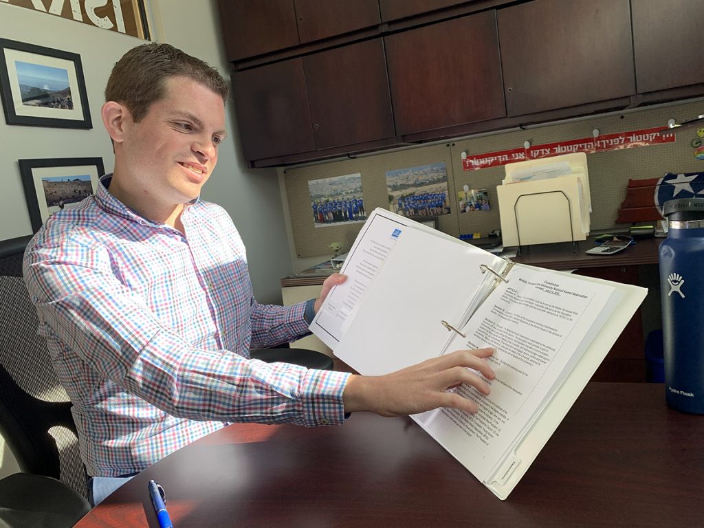In his Todd Hall office, Matthew Hibdon reviews some of the MTSU National Alumni Association Board's constitution and by-laws. He is the 2021-22 board president. (MTSU photo by Randy Weiler)