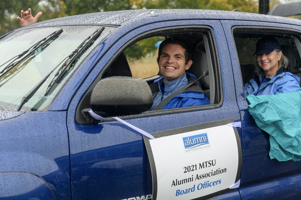 As National Alumni Association Board President Matthew Hibdon, left, drives, Secretary Mary Kinney, right, and Vice President Michael Hogan and Treasurer Debbie Hickerson ride in the 2021 MTSU Homecoming Parade in the rain. (MTSU file photo by J. Intintoli)